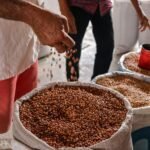 a group of people standing around a table full of food