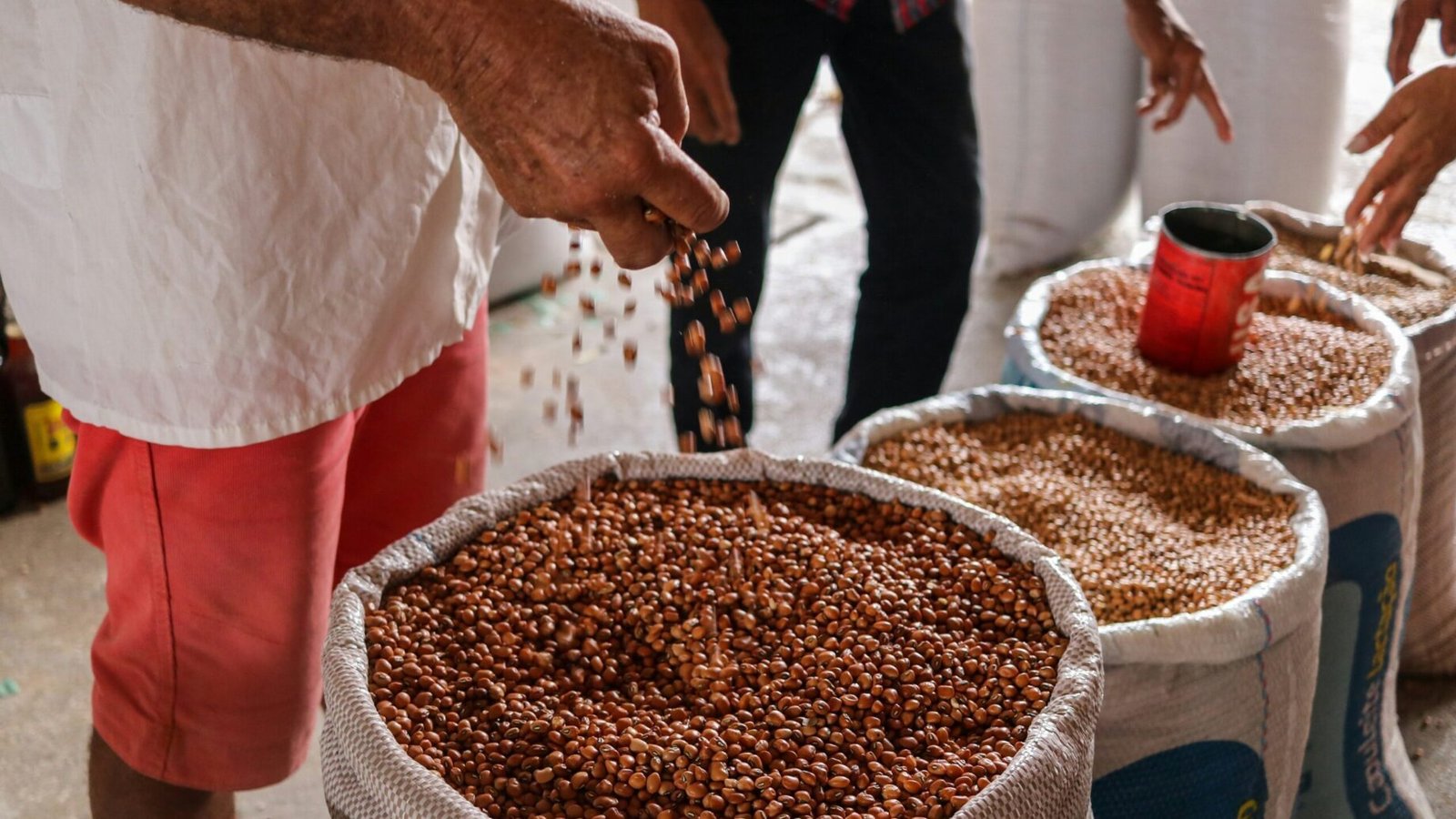 a group of people standing around a table full of food